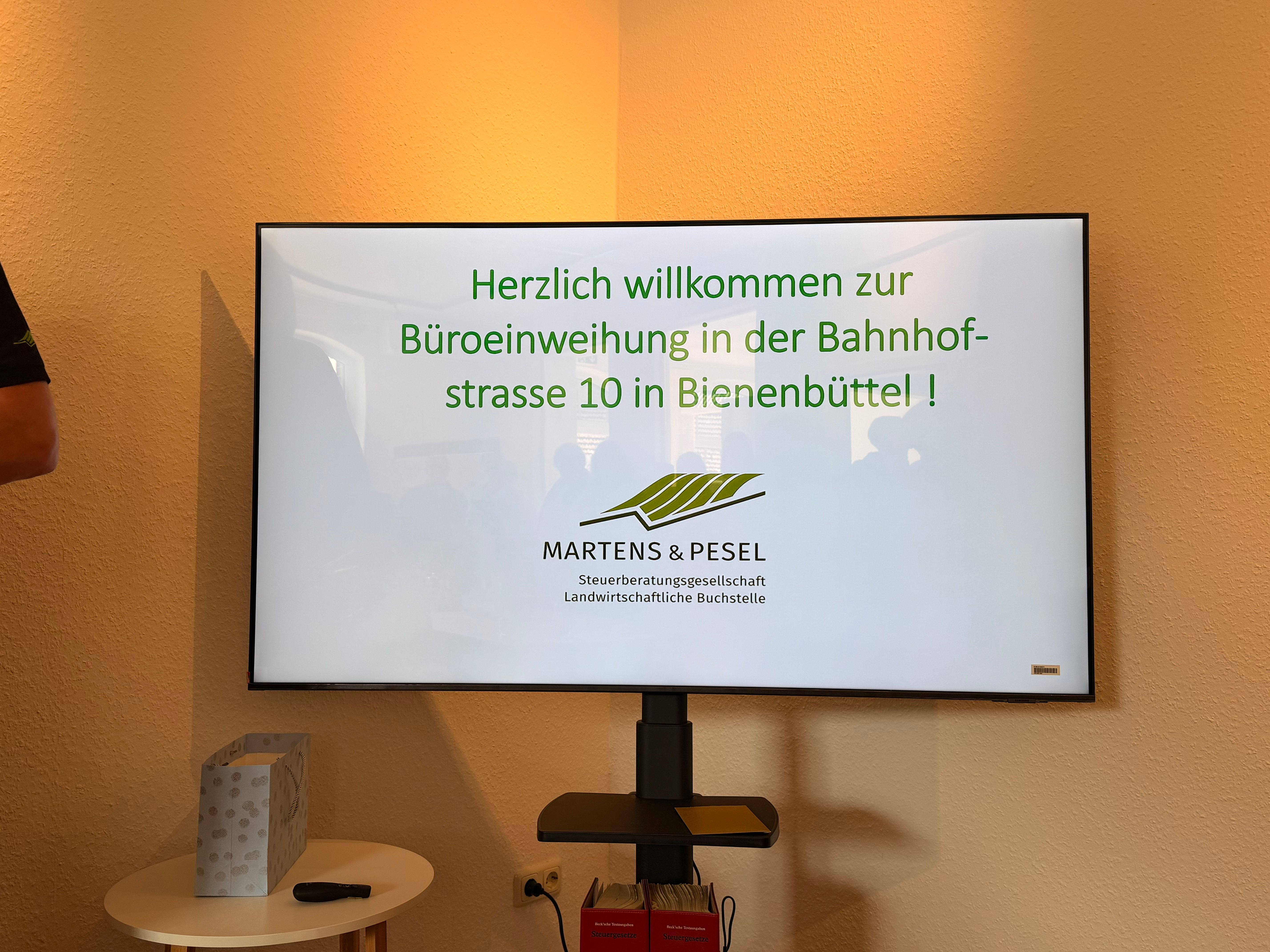Ein Fernsehbildschirm begrüßt die Teilnehmer der Einweihungsfeier.